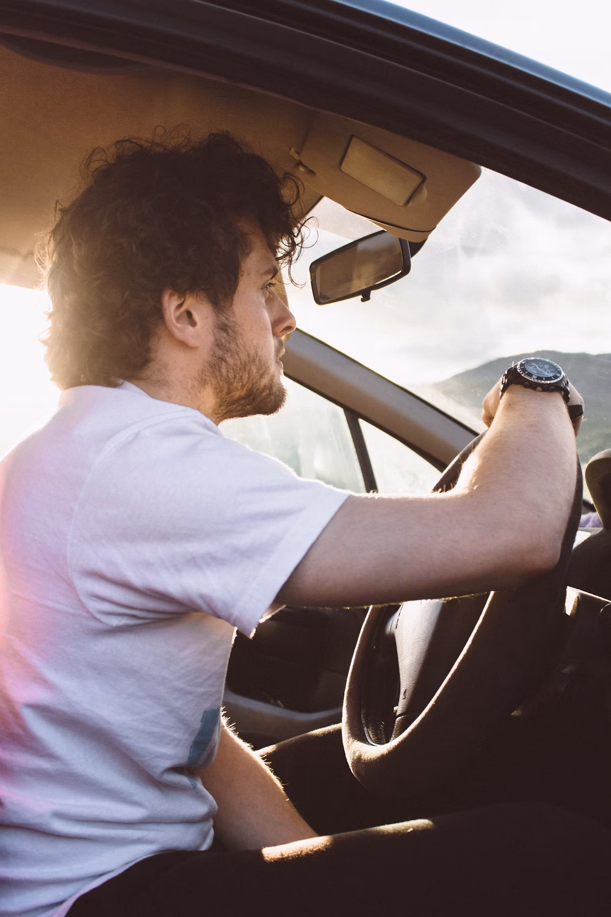 Driver looking out over an open road at golden hour
